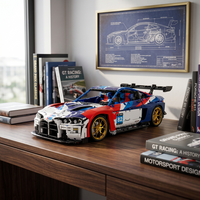 BMW M4 GT3 Racing en briques 1:8 posée sur un bureau avec cadre blueprint GT Racing en arrière-plan