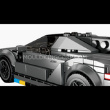 Voiture miniature en briques vue du dessus avec cockpit détaillé et structure technique.